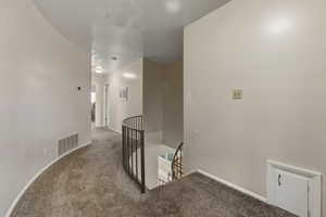 Corridor featuring an upstairs landing and carpet