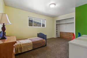 Bedroom featuring dark colored carpet and a closet