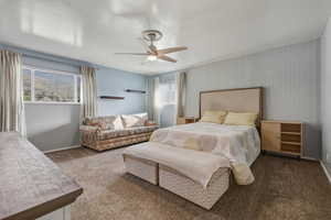 Carpeted bedroom with ceiling fan and baseboards