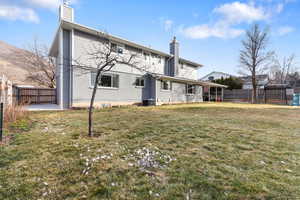 Back of property featuring a chimney, a fenced backyard, and brick siding