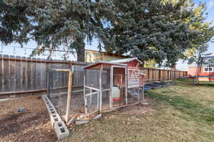 Fenced backyard with exterior structure, a sunroom, an outdoor structure, and a trampoline