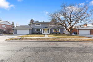 View of front of home with driveway, brick siding, and a garage