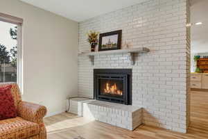Detailed view of wood finished floors and a brick fireplace