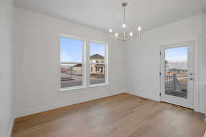 Unfurnished dining area with a chandelier and light wood-style flooring