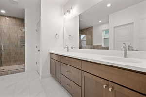 Bathroom with double vanity, a stall shower, recessed lighting, and light marble finish floors