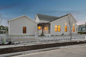 View of front of home with a fenced front yard and covered porch