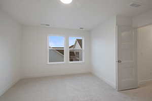 Empty room featuring light carpet and baseboards