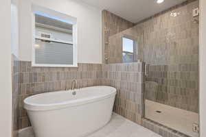 Full bathroom with a stall shower, tile walls, a soaking tub, and marble finish flooring