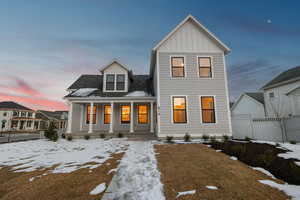 View of front of property with covered porch, a shingled roof, and board and batten siding