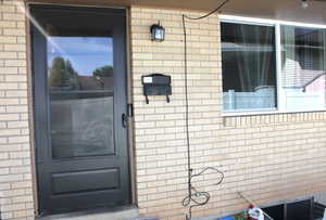 View of exterior entry featuring brick siding