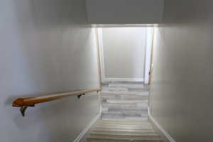 Staircase featuring baseboards and wood finished floors