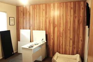 Interior space featuring wood walls currently used as an office