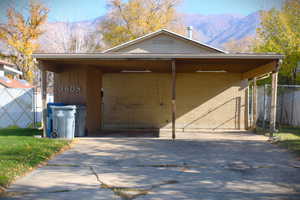 View of front facade featuring a mountain view, driveway, and an attached carport