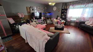 Living area with dark wood finished floors and a chandelier