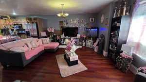 Living room featuring a textured ceiling and dark wood-style flooring