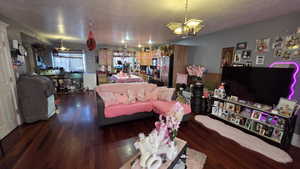 Living room with a textured ceiling and dark wood-type flooring