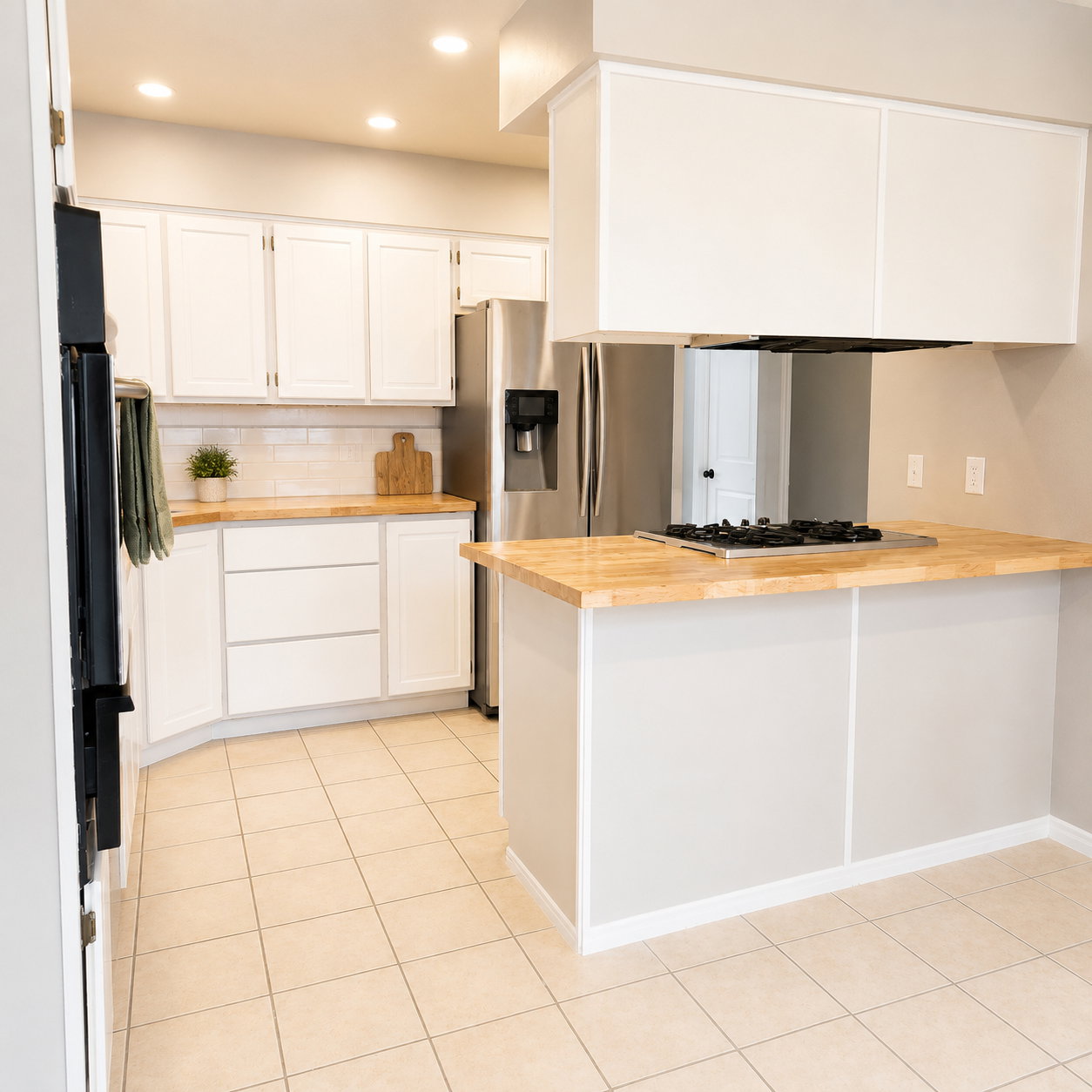 Kitchen featuring light wood-finish countertops, white cabinetry, and stainless steel appliances