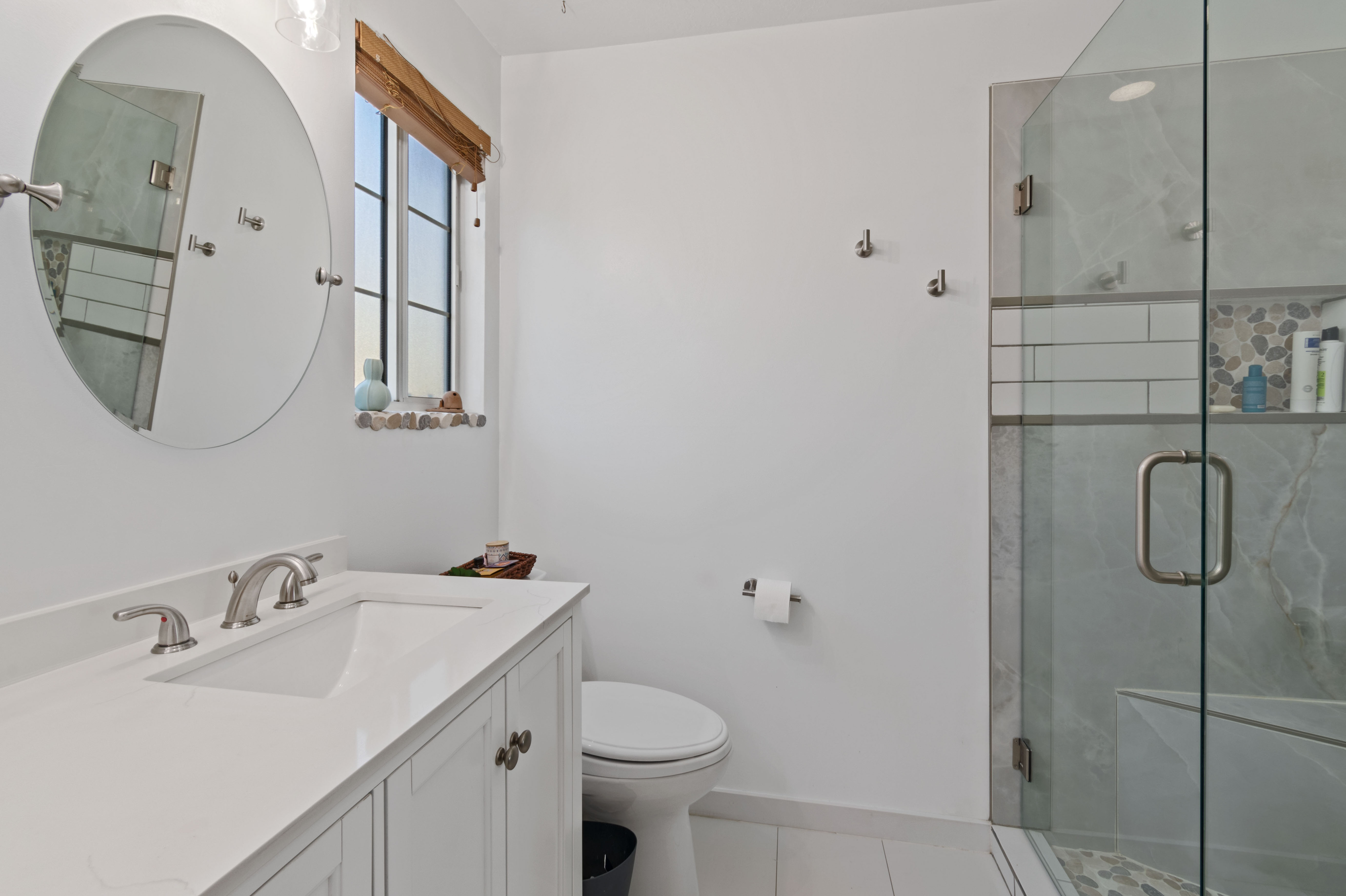 Full bath with a marble finish shower, vanity, and light tile patterned floors