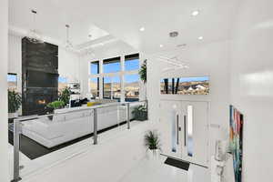 Tiled entryway featuring a towering ceiling, a large fireplace, recessed lighting, and a chandelier