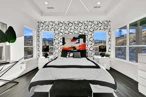 Bedroom with dark wood-style flooring, a mountain view, multiple windows, and recessed lighting