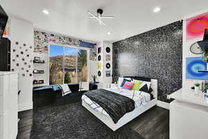 Bedroom featuring an accent wall, dark wood-type flooring, wallpapered walls, recessed lighting, and a ceiling fan
