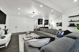 Living room with recessed lighting, a chandelier, and dark wood-style flooring