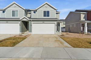 View of front of home with concrete driveway and an attached garage