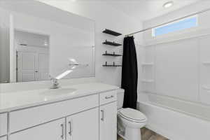Full bath featuring shower / bathtub combination with curtain, vanity, and light wood-type flooring