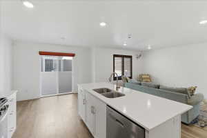 Kitchen featuring white cabinets, open floor plan, appliances with stainless steel finishes, light wood-type flooring, and recessed lighting