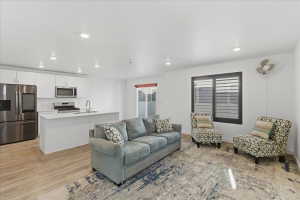 Living room with recessed lighting and light wood-style flooring