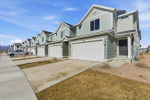 Traditional-style home with driveway, an attached garage, and a residential view