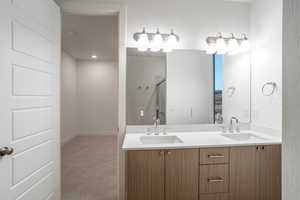 Full bath featuring double vanity, a stall shower, and light carpet
