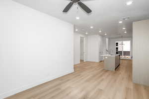 Unfurnished living room featuring light wood-style floors, recessed lighting, a chandelier, and a ceiling fan
