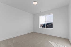 Unfurnished room with light carpet and baseboards