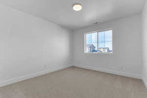 Empty room with baseboards and light colored carpet