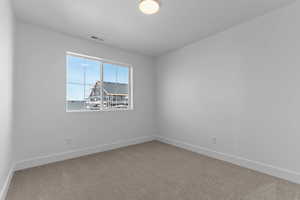 Spare room with light colored carpet and baseboards