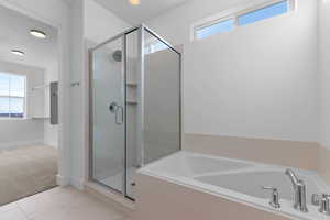 Bathroom featuring a shower stall, a garden tub, and light colored carpet