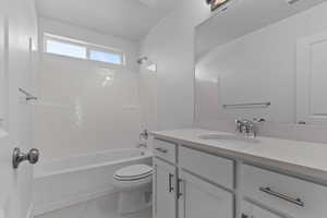 Bathroom featuring vanity, shower / tub combination, and light marble finish flooring