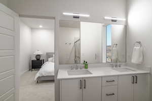 Ensuite bathroom featuring double vanity, a stall shower, light carpet, and recessed lighting