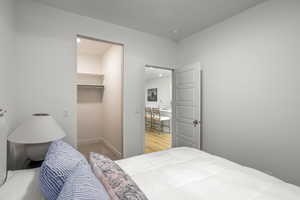 Bedroom featuring a spacious closet and baseboards