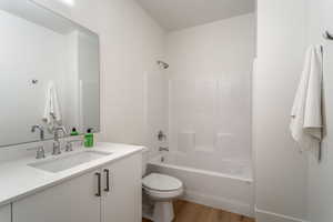 Bathroom with vanity, bathtub / shower combination, and light wood-style floors