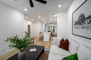 Living area with light wood finished floors, a ceiling fan, and recessed lighting