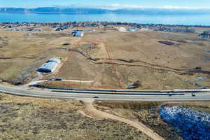 Aerial view of property and surrounding area with a mountainous background and property boundaries highlighted