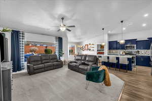 Living area featuring vaulted ceiling, a ceiling fan, and a chandelier