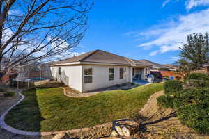 Back of house with a trampoline, a fenced backyard, stucco siding, and a patio area