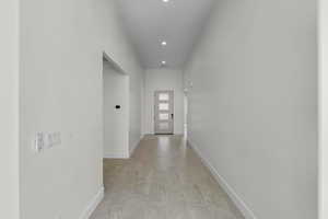 Corridor with baseboards and recessed lighting