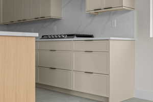 Kitchen featuring light tile patterned flooring, light countertops, and stainless steel gas stovetop