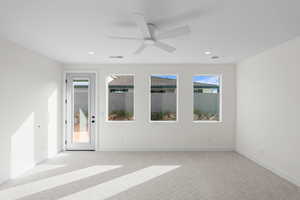 Unfurnished room featuring light carpet, ceiling fan, and recessed lighting