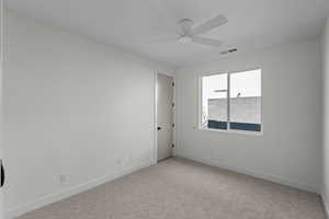 Carpeted spare room with baseboards and a ceiling fan