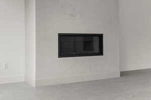 Detailed view of baseboards and a glass covered fireplace